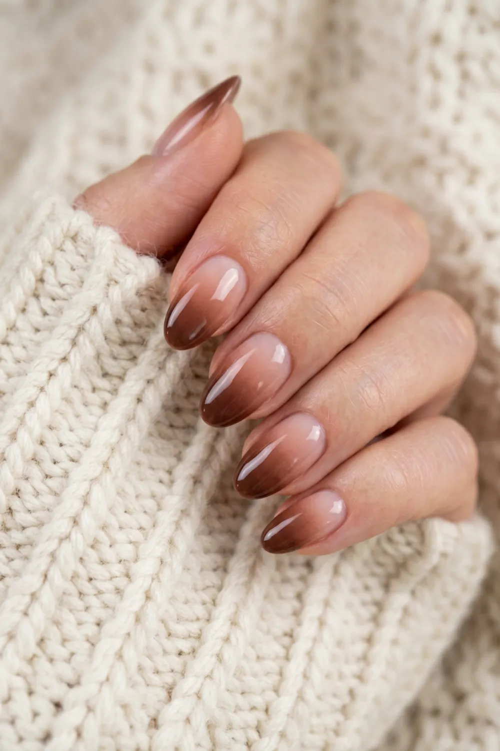 Almond nails fading from sheer nude at the cuticle to mocha brown at the tips