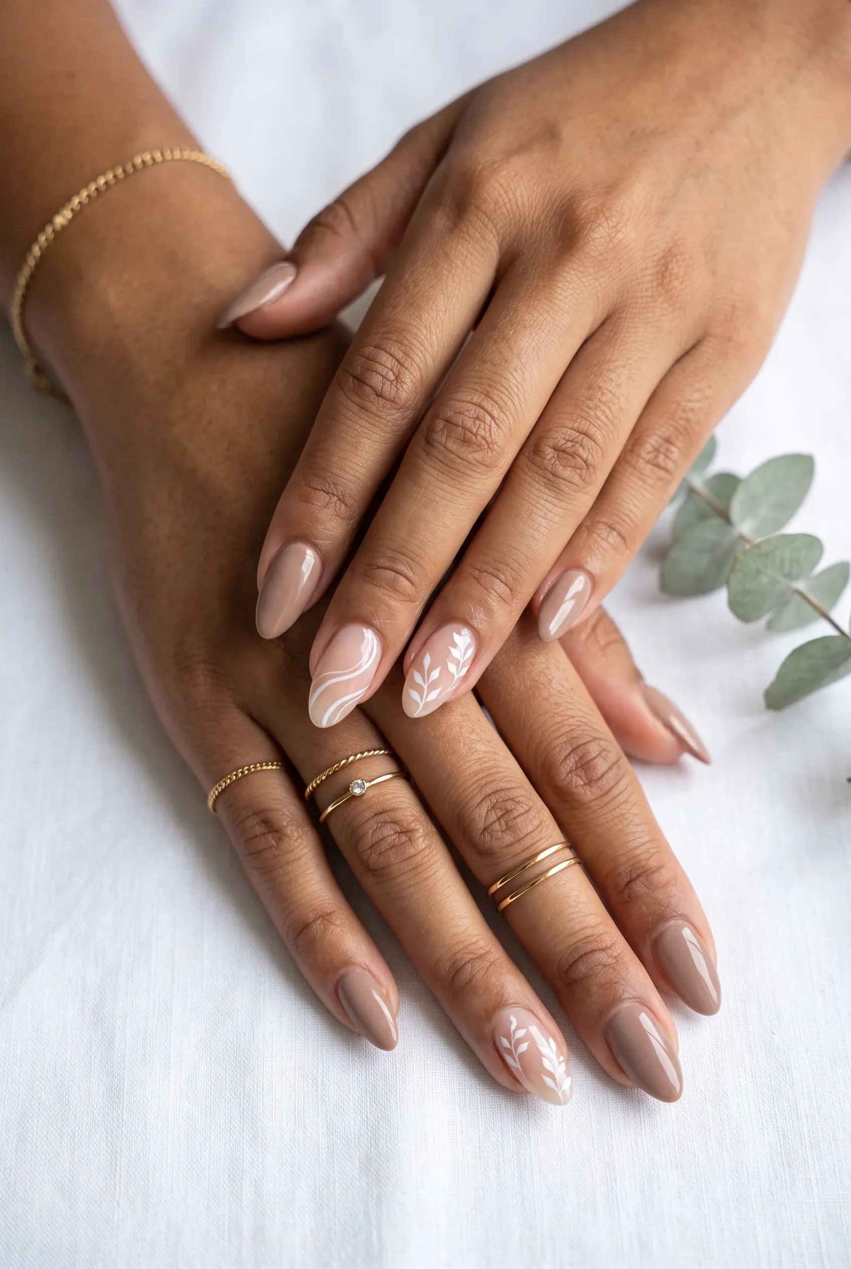 Almond nails in taupe brown with white leaf swirl art on nude accent nails