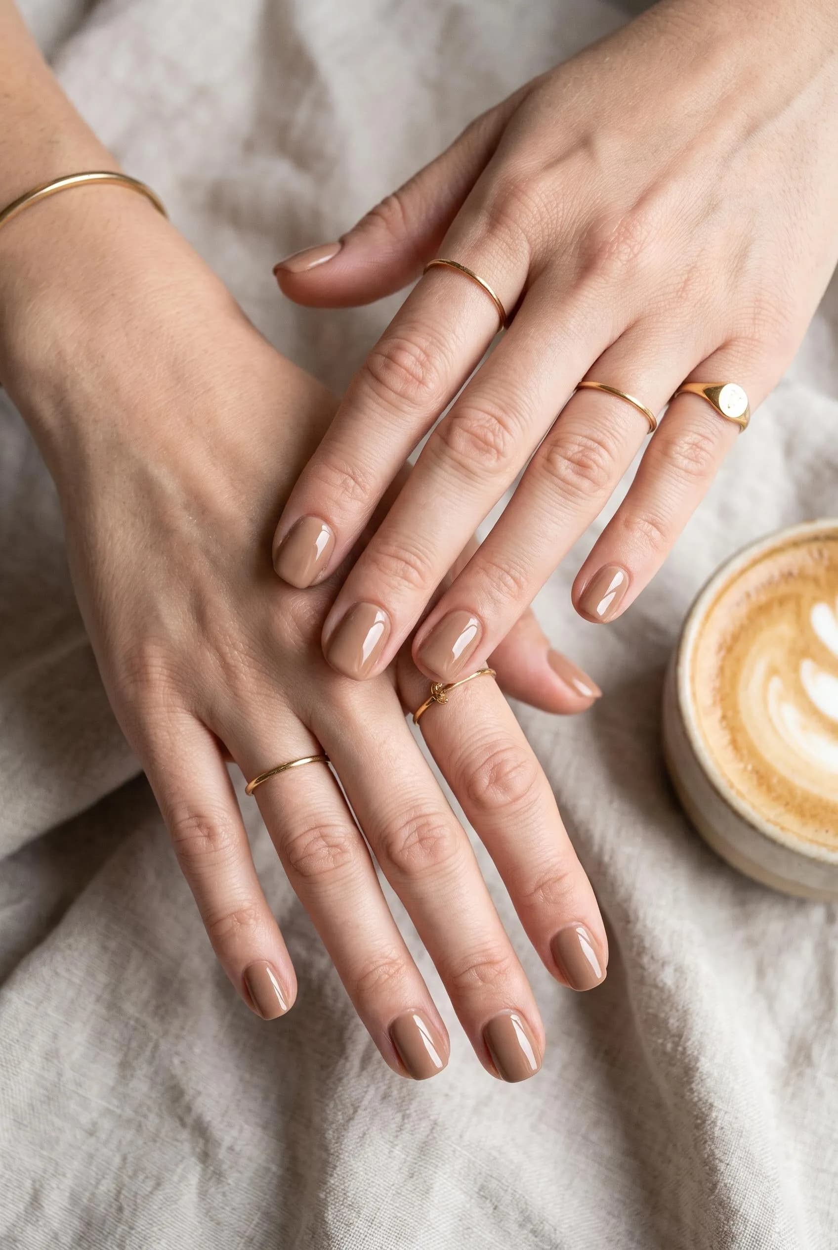 Creamy mocha squoval nails beside a cappuccino