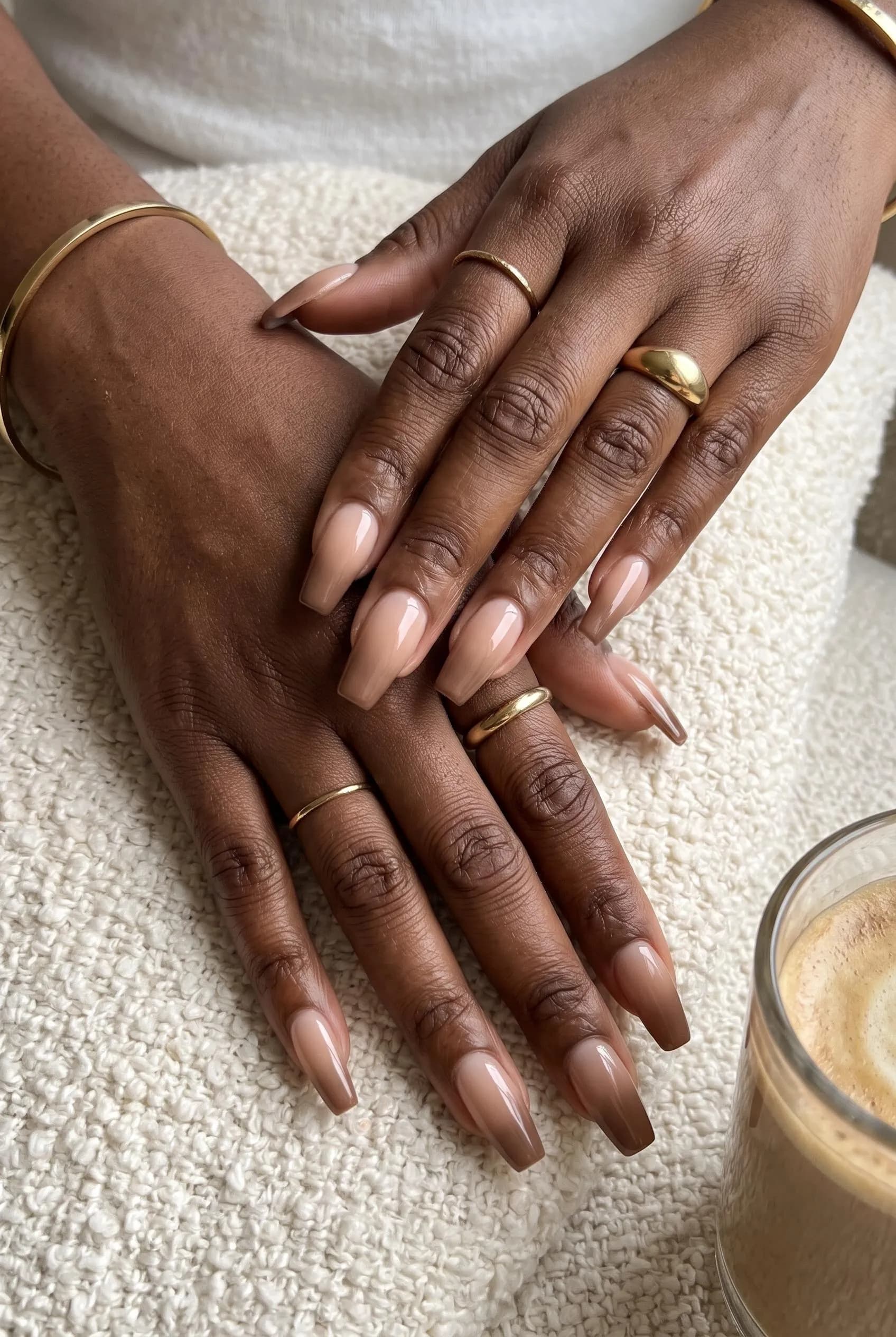 Long coffin nails with a nude to mocha ombre on deep brown skin