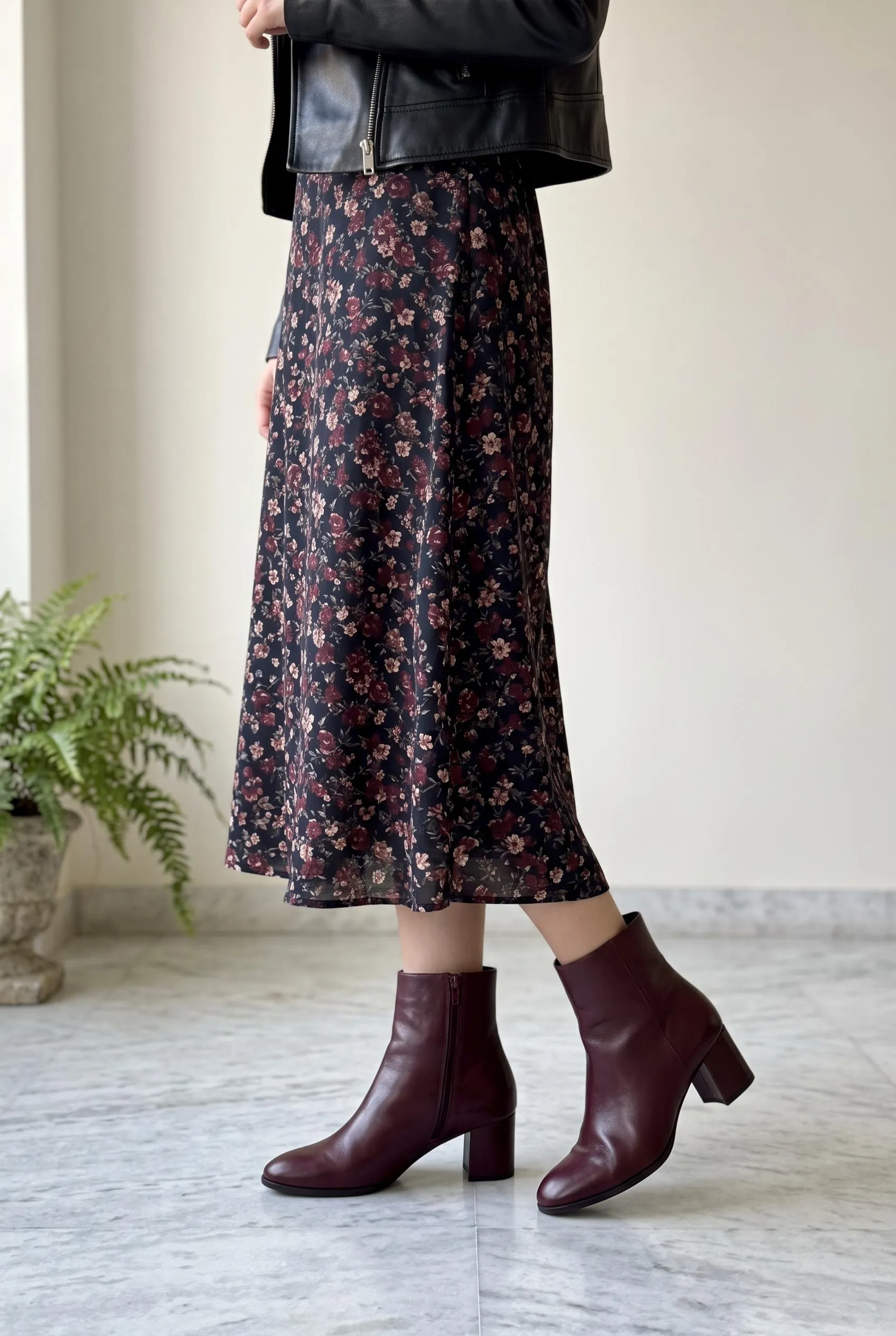 Burgundy ankle boots with a dark floral midi dress and a black leather jacket