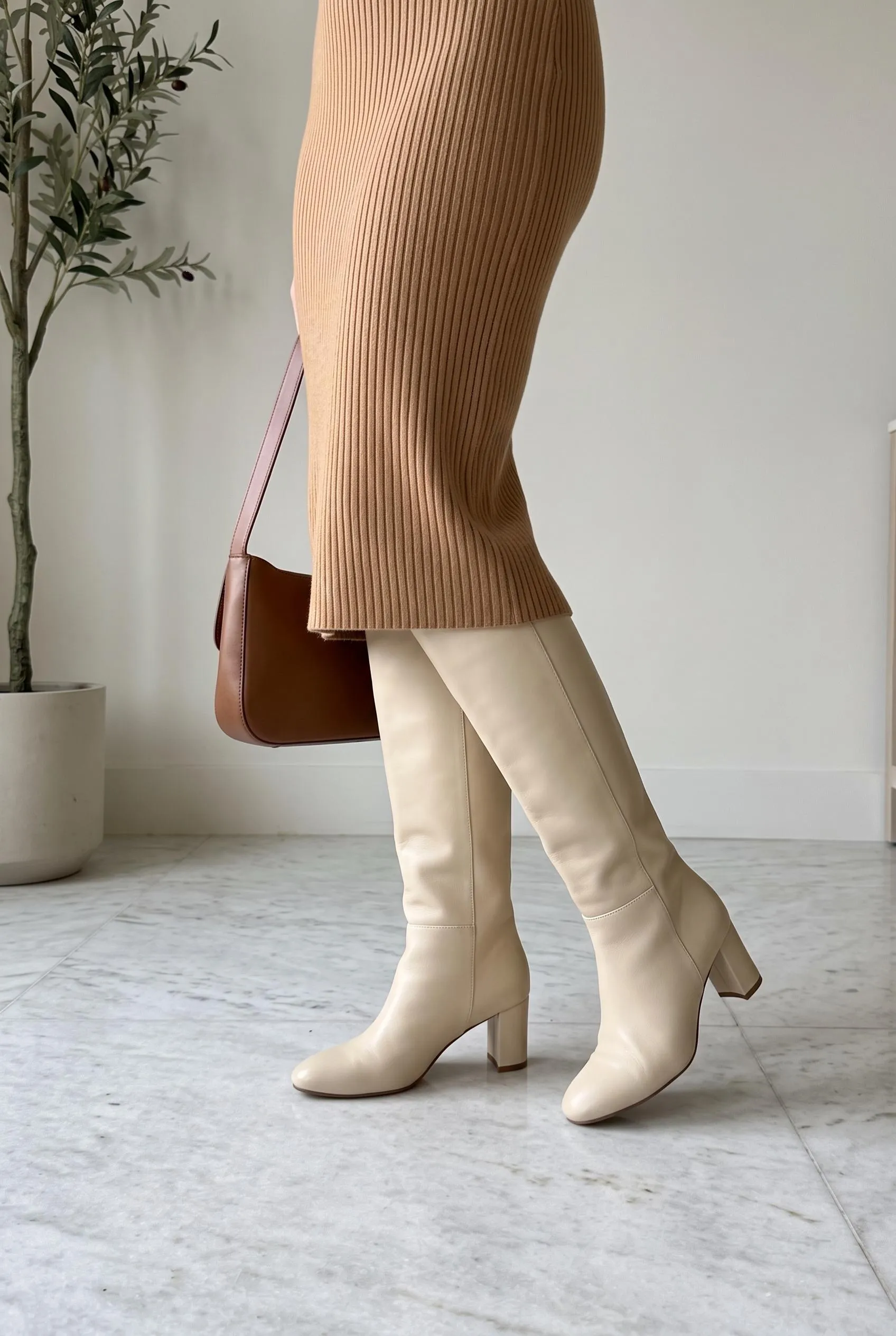 Cream leather knee-high boots with a camel ribbed knit midi dress and a brown bag