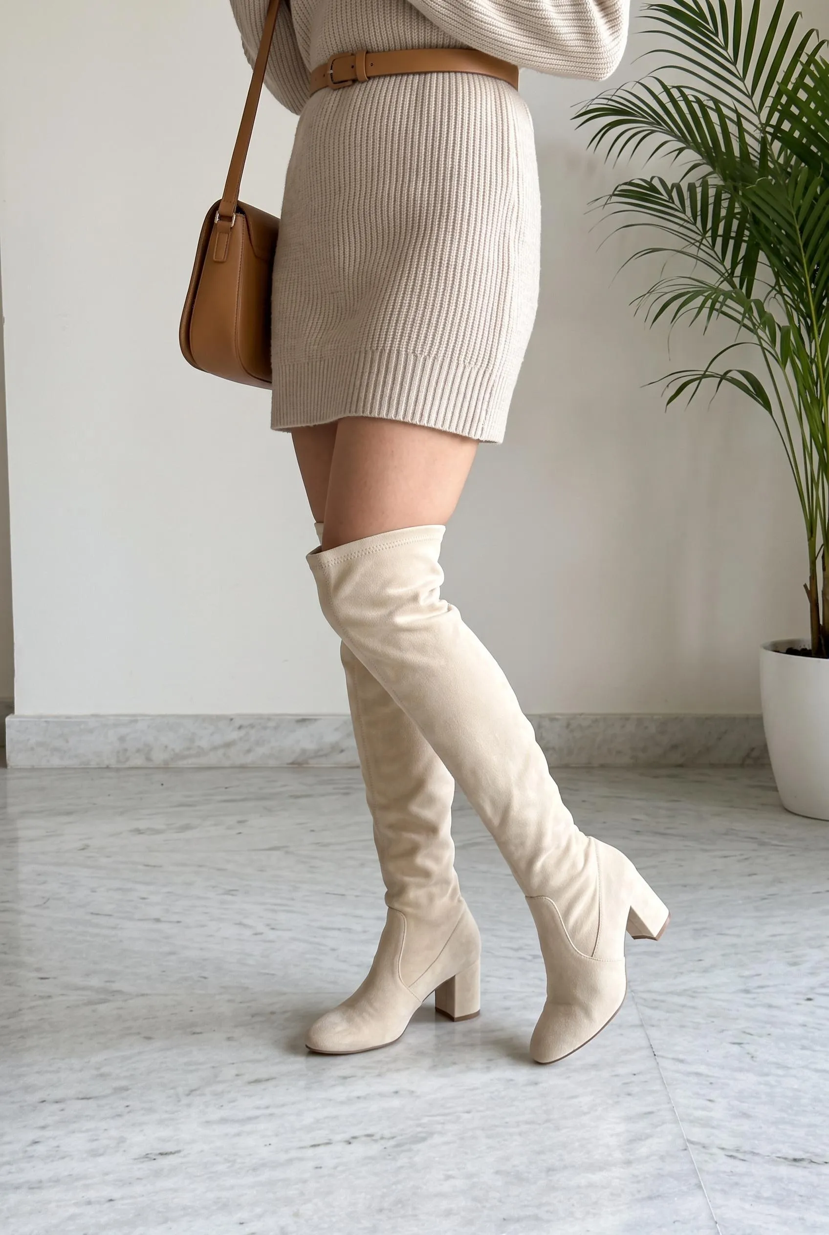 Cream suede over-the-knee boots with a short oatmeal sweater dress and a camel belt