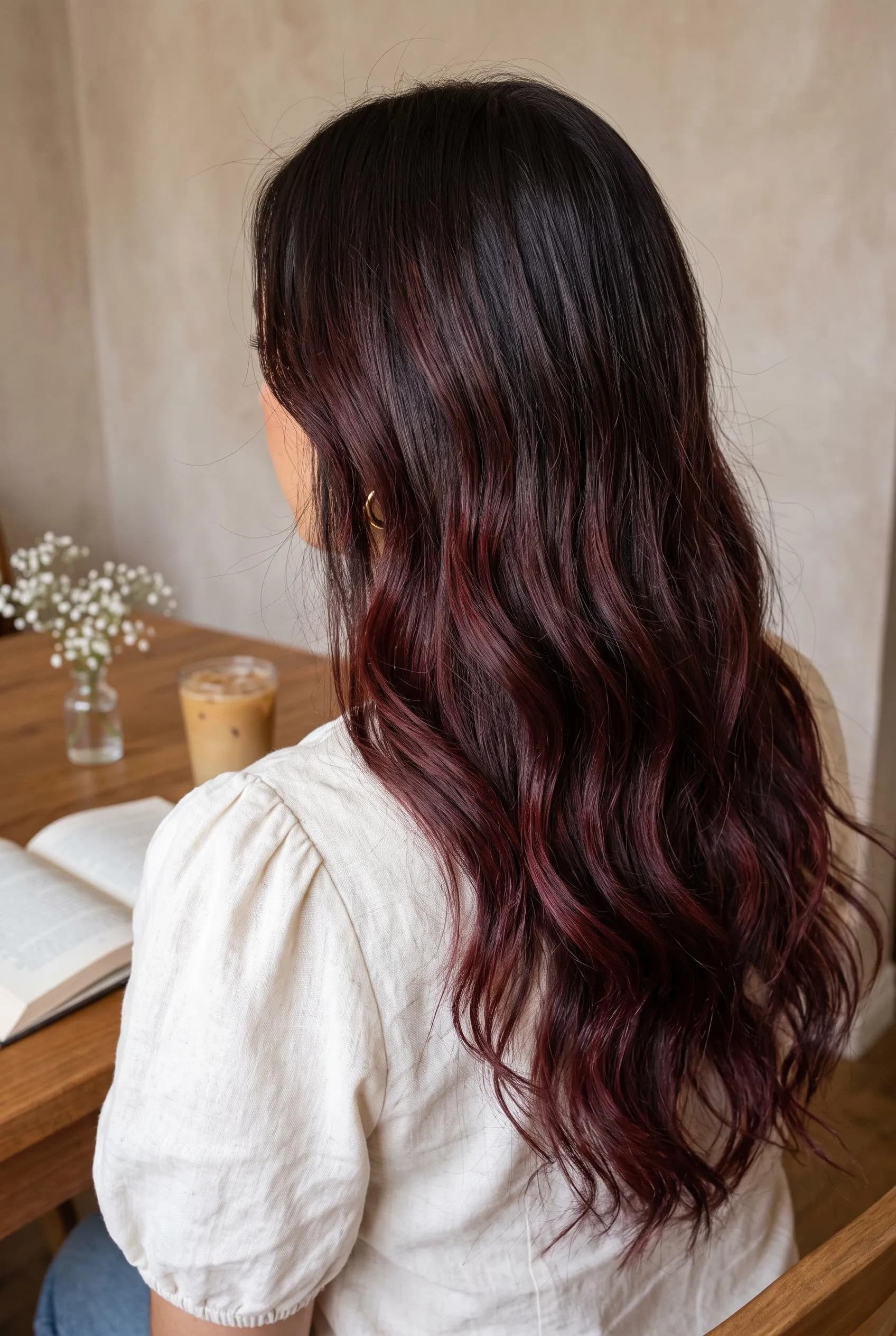 Long dark brown waves with soft burgundy wine balayage through the ends