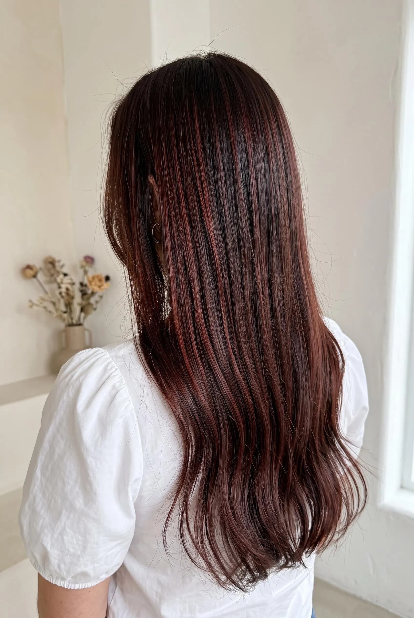 Long sleek dark brown hair with fine cherry cola ribbon highlights