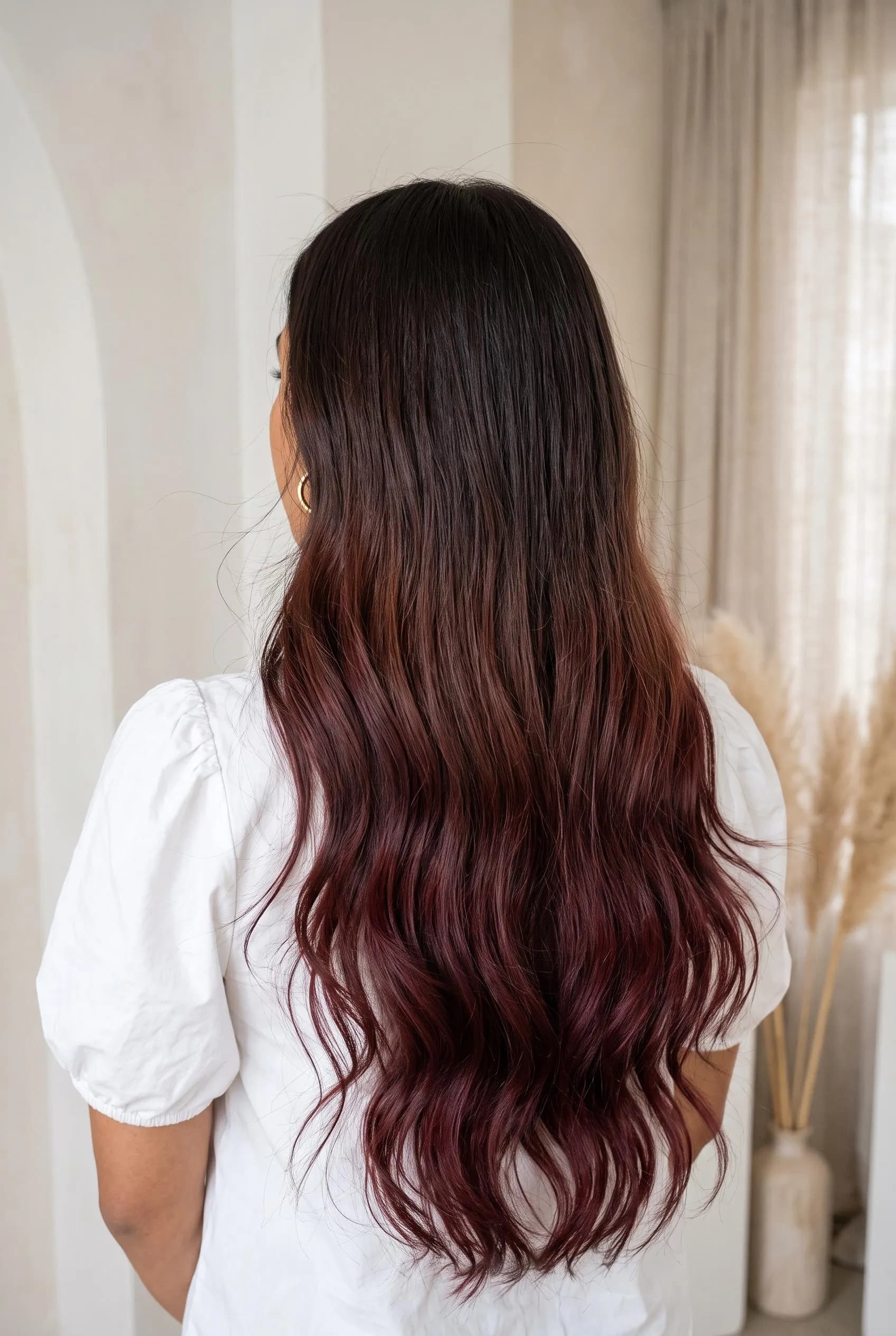 Dark brown roots melting into burgundy wine ombre waves