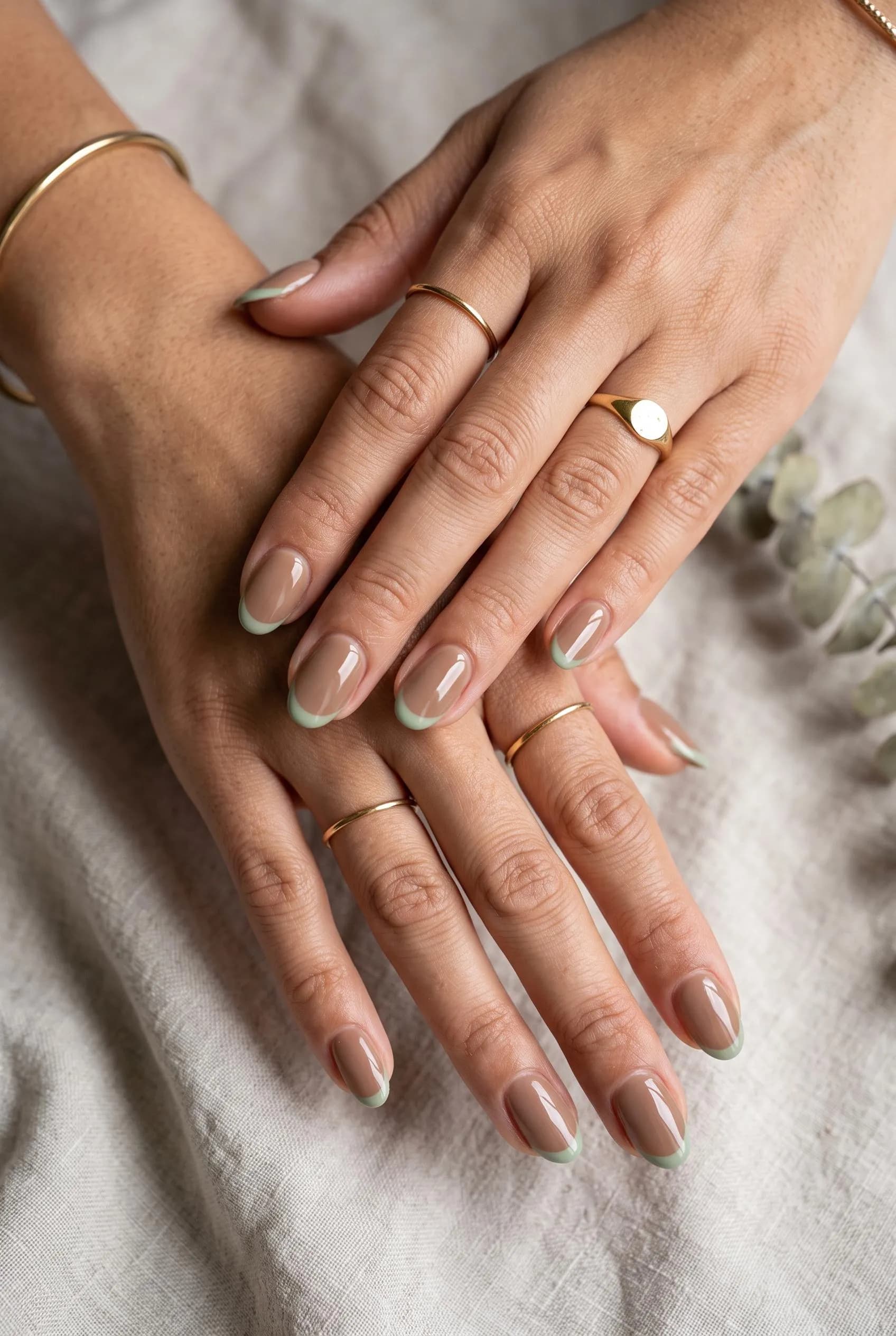 Creamy mocha oval nails with thin sage green French tips