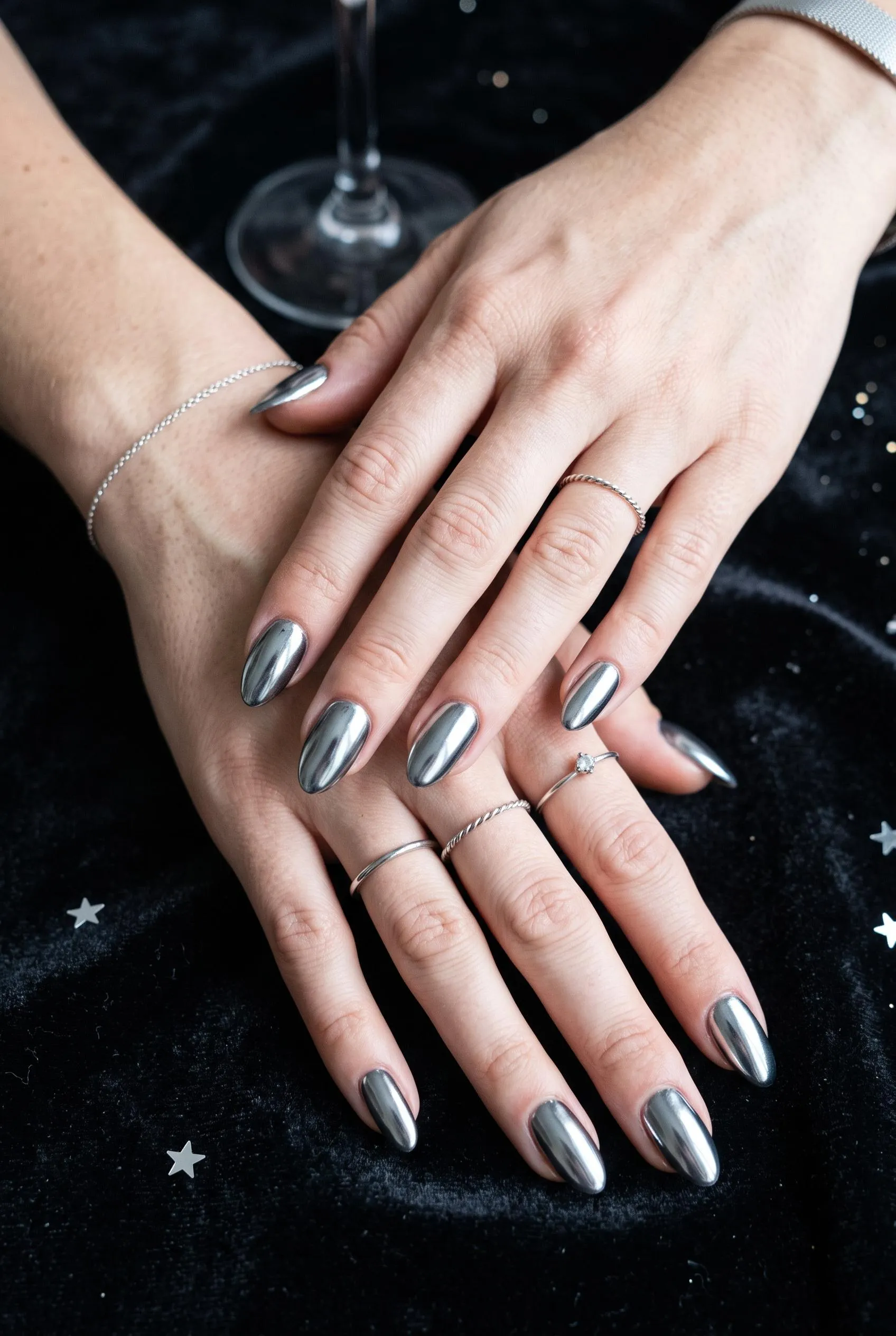 Almond nails with a sheer nude base and gold glitter French tips