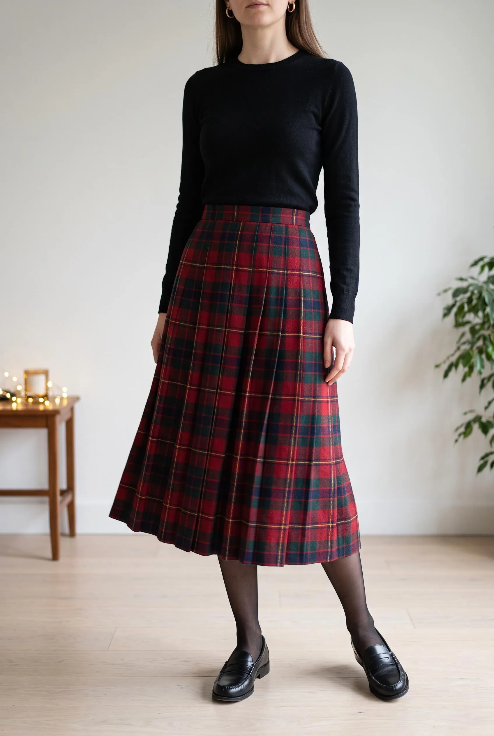 Red tartan pleated midi skirt with a black knit top and black loafers