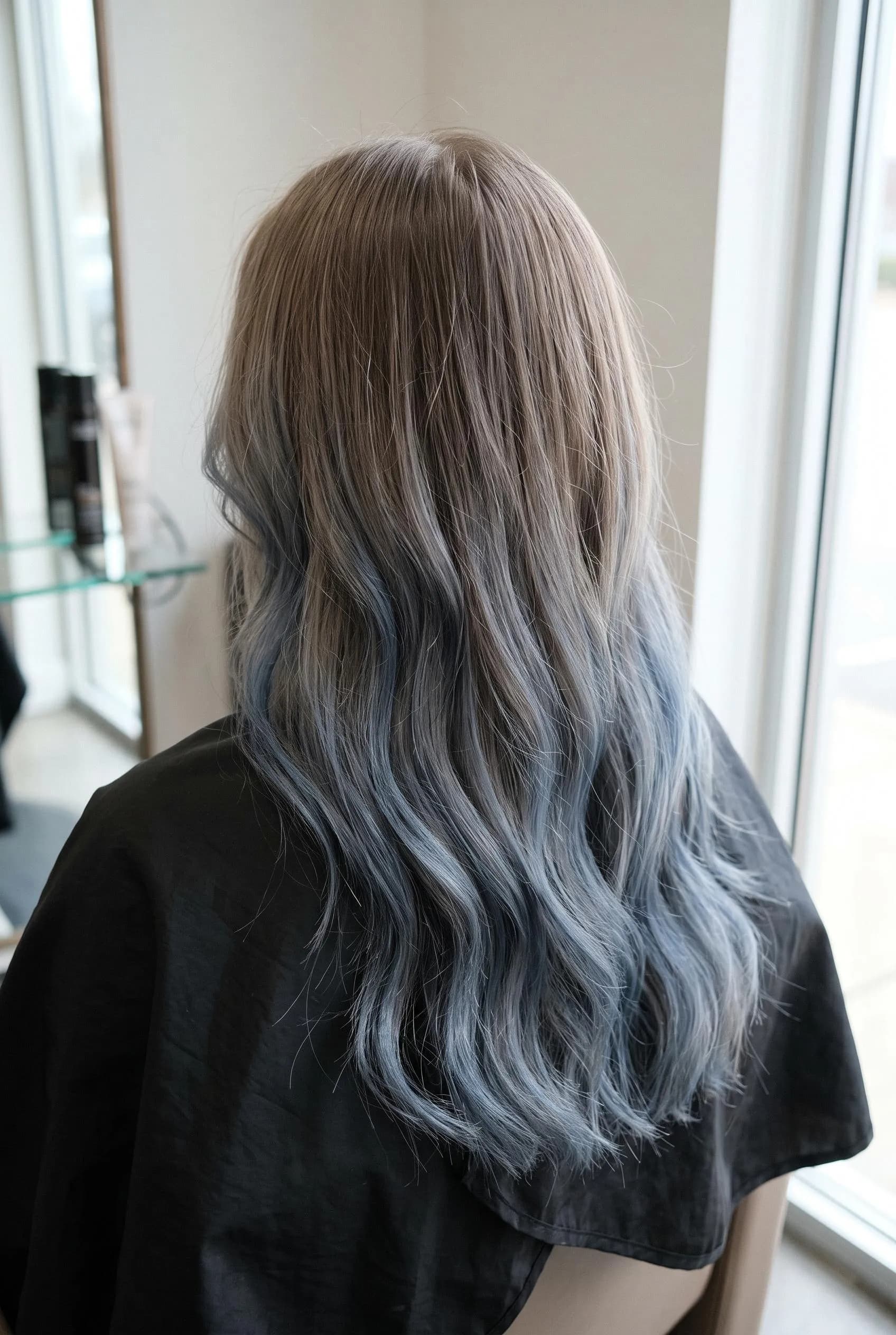 Light ash brown waves with soft denim blue balayage through the ends