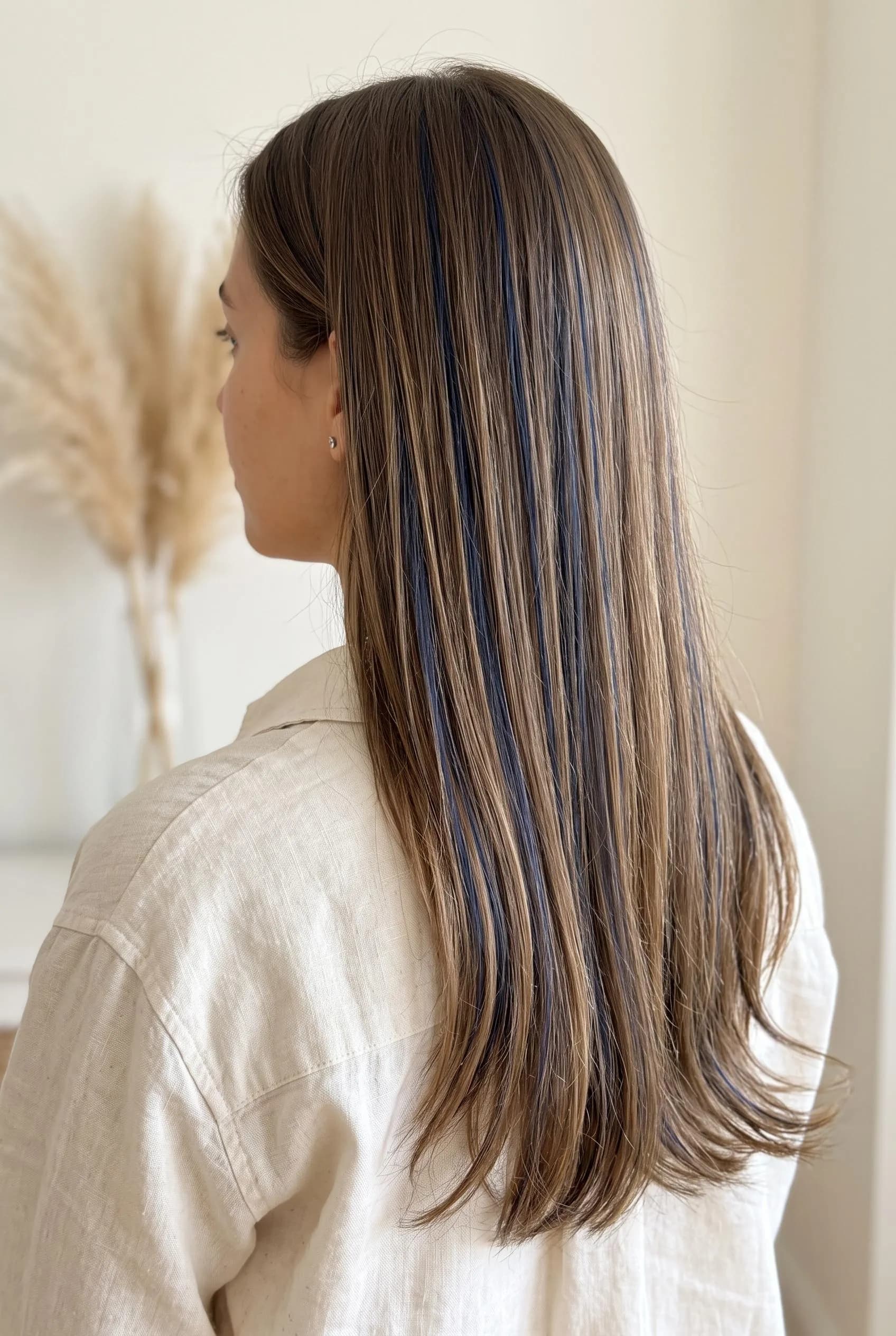 Straight light brown hair with fine navy blue ribbon highlights