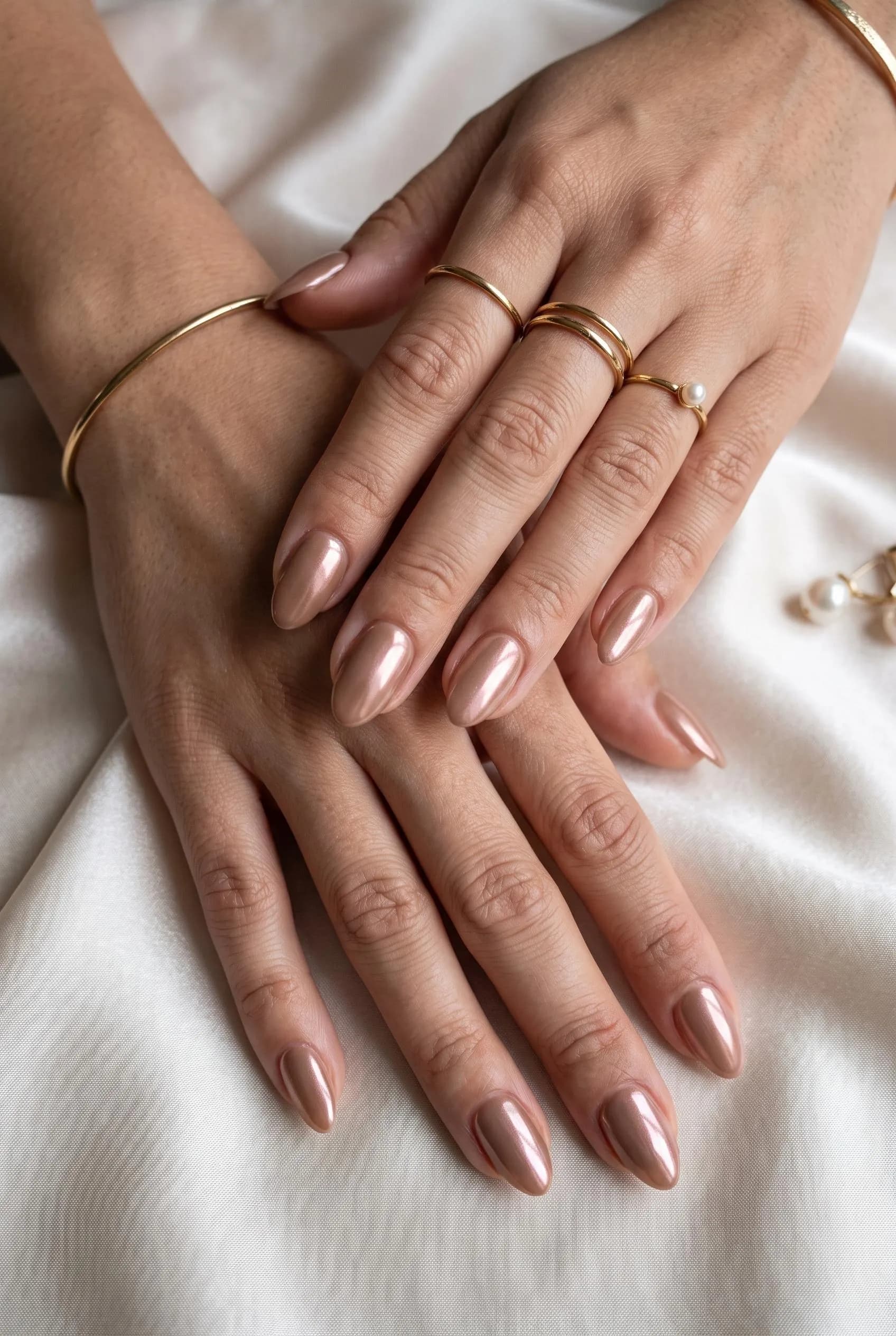 Glazed mocha almond nails with a sheer pearl chrome finish on ivory silk