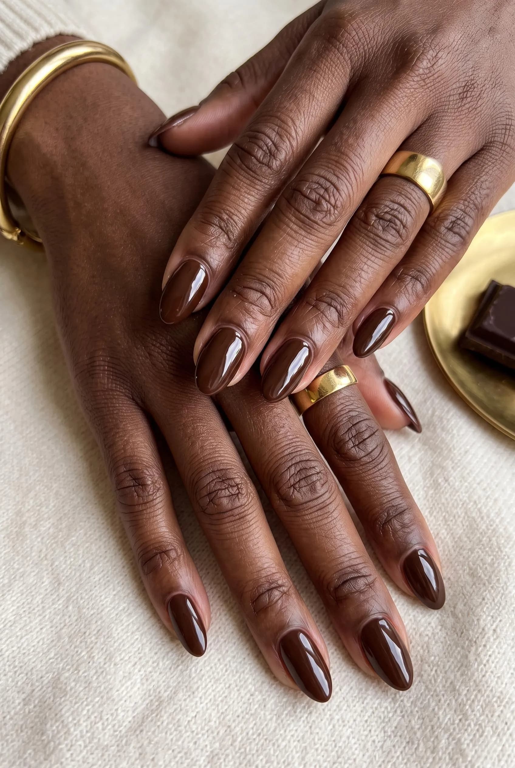 Glossy chocolate brown almond nails on deep brown skin