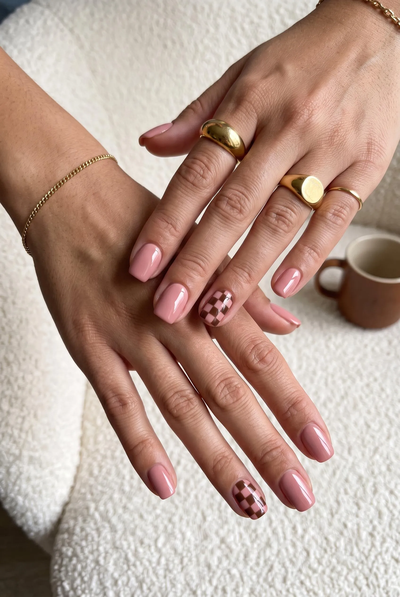 Dusty pink nails with a pink and brown checkerboard on the accent nails