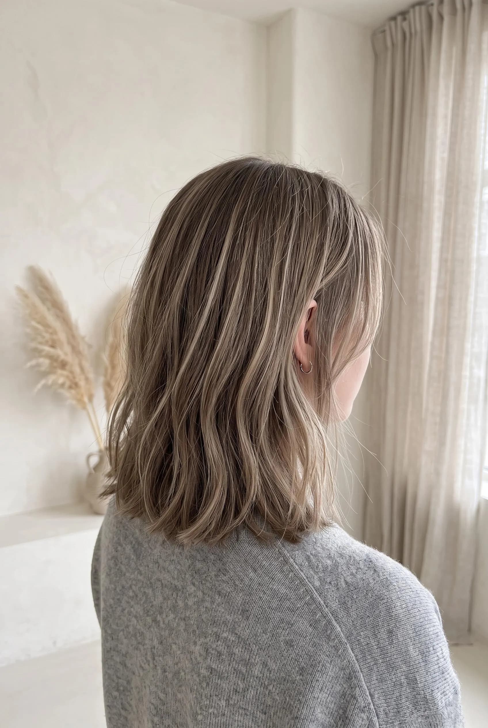 Shoulder-length ash brown hair with cool beige blonde highlights